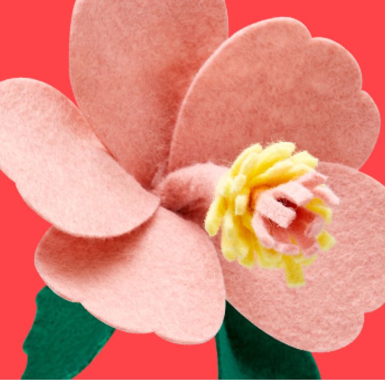 Pink artificial woolen flower on the red background