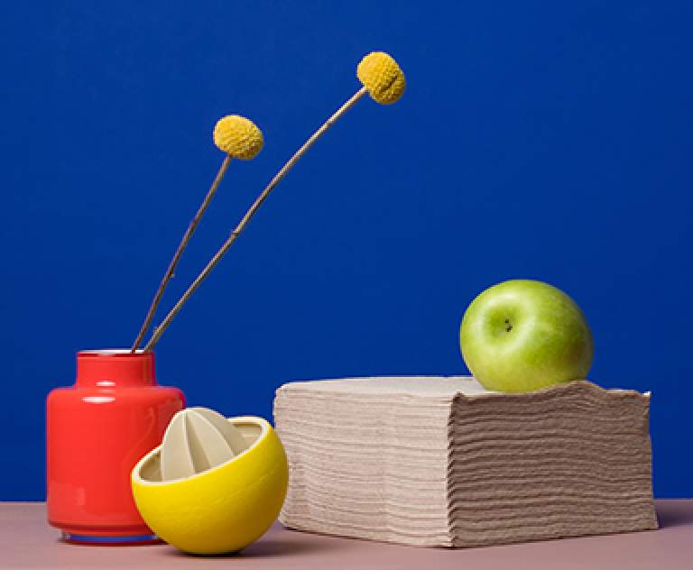 Composition of a lemon squeezer, an apple and a stack of napkins