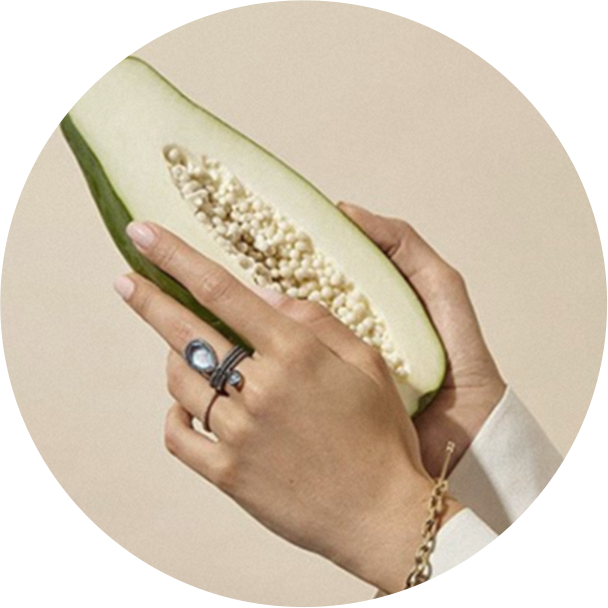 Hands with a ring and a brecelet holding a papaya